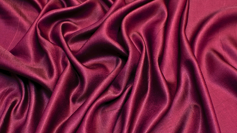 A close up of a burgundy viscose rayon fabric