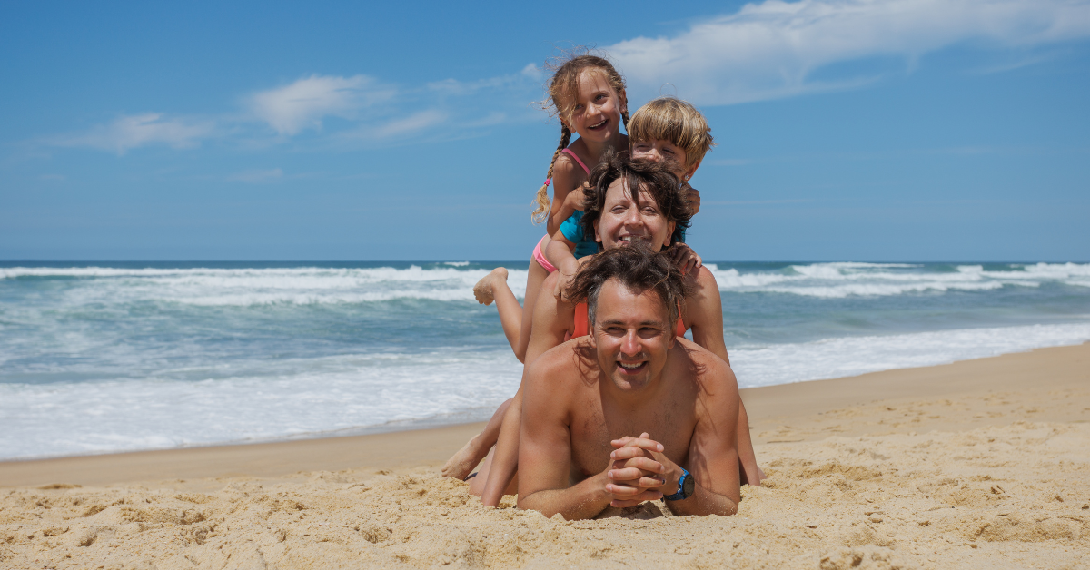 Family enjoying a sunny day at the Jersey Shore beach with ocean waves in the background, perfect for summer vacation memories.
