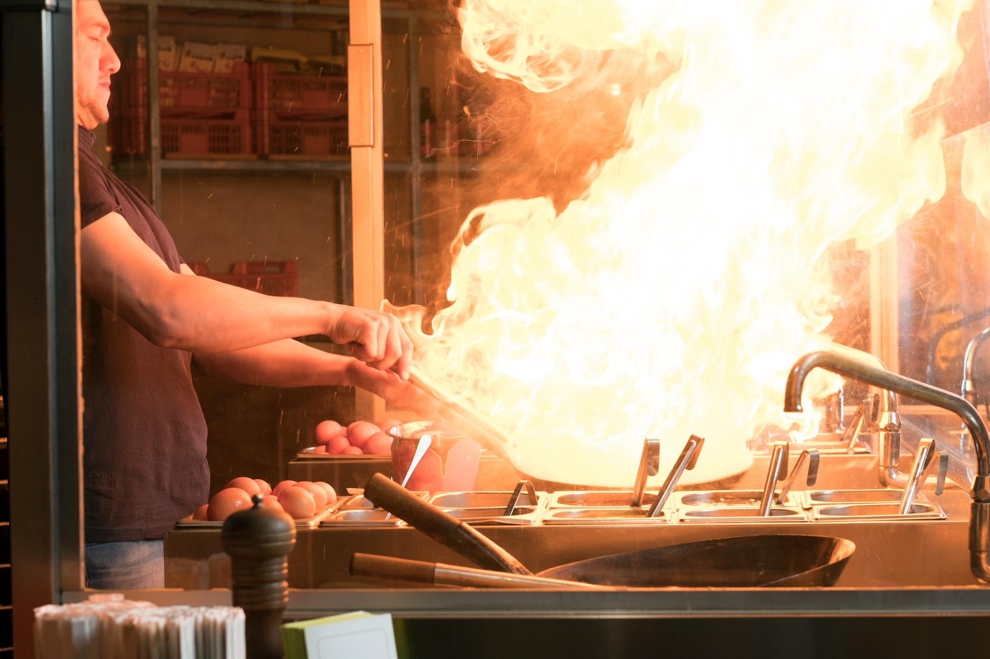 A man cooking in a commercial kitchen