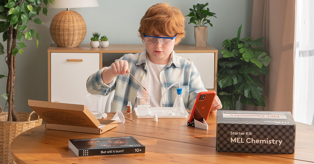 An image of a young child wearing safety goggles while conducting an experiment from the kids chemistry set.