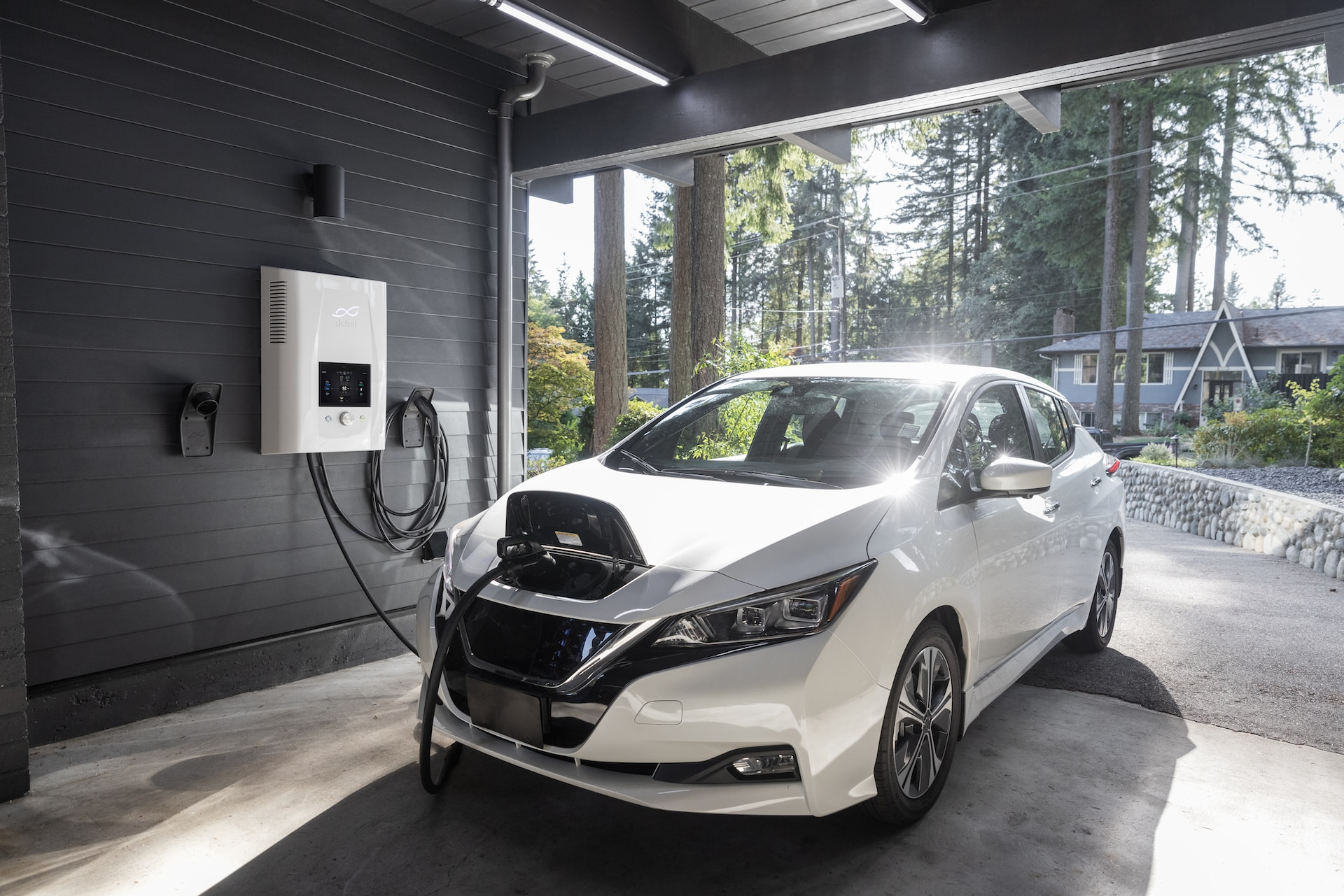 A white electric vehicle charging on a solar EV charging station. 