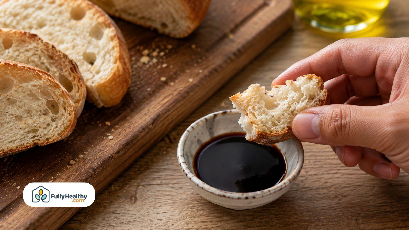 Bread dipped into soy sauce beside sliced bread on board.