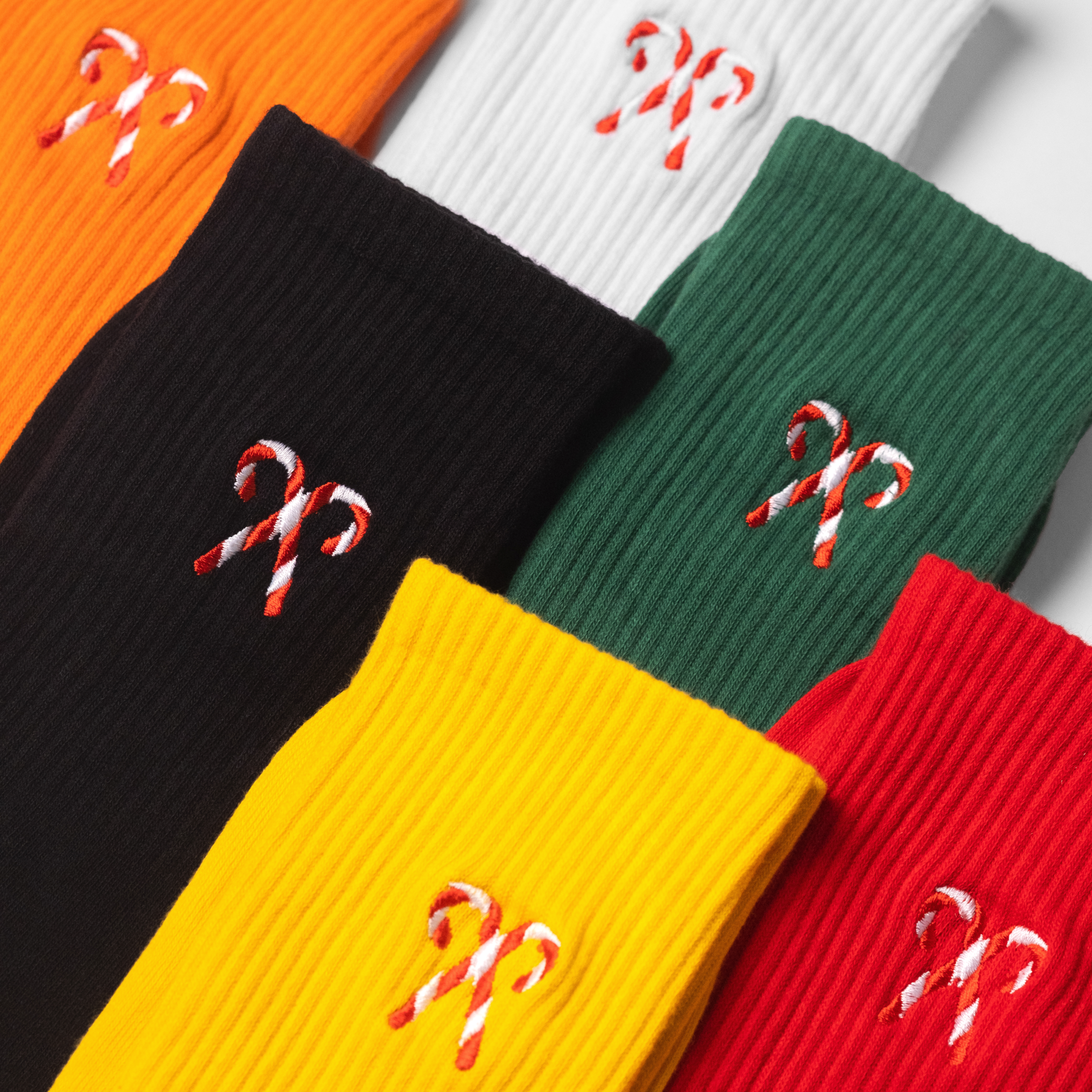 A colourful collection of mens crew socks with a candy cane embroidered on each sock of the pair.