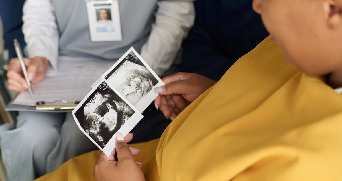 Surrogate holding the scans of the unborn baby she is carrying for the intended parents