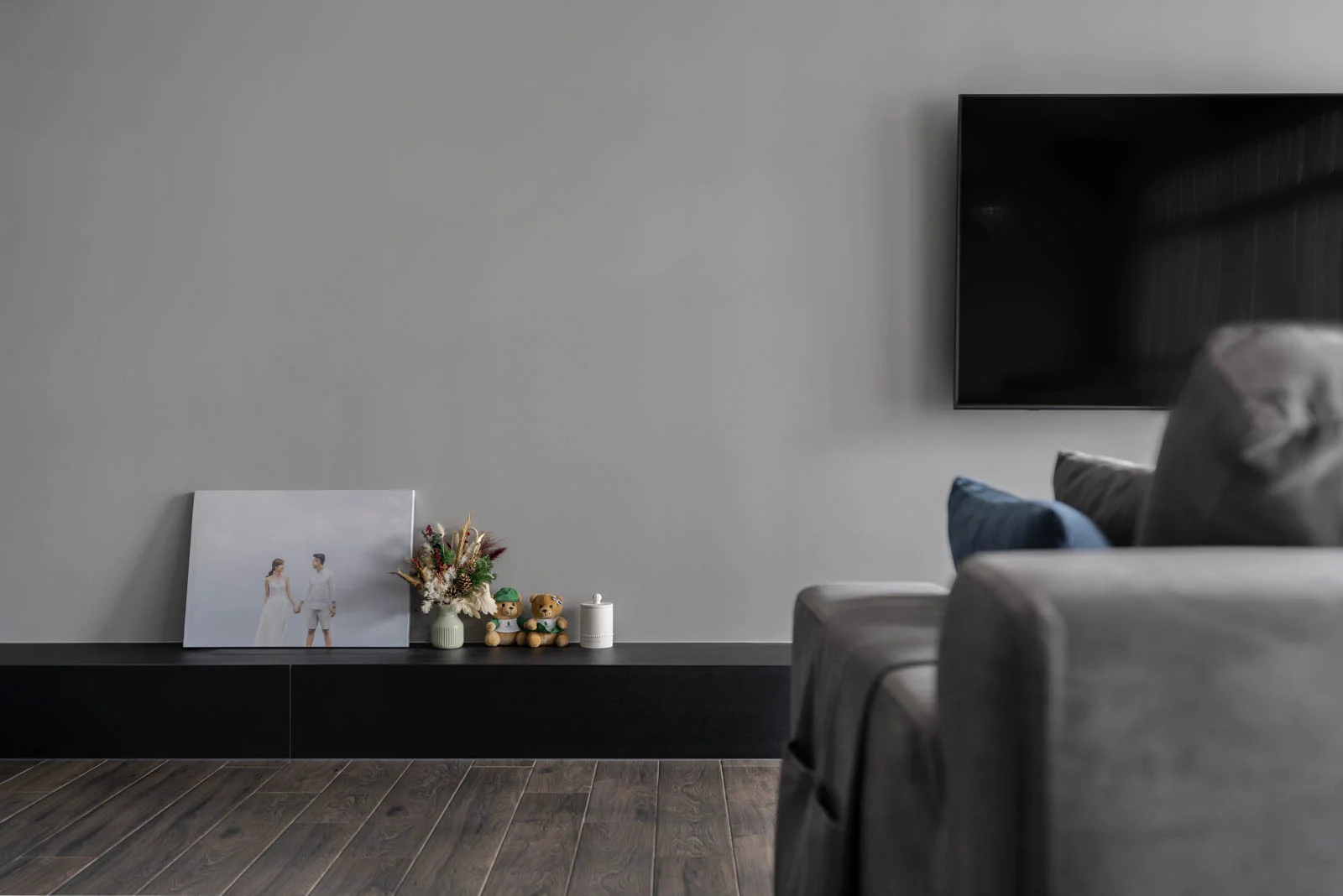 Minimalist lounge with grey sofa, low black console and curated décor accents in a Kuala Lumpur condo