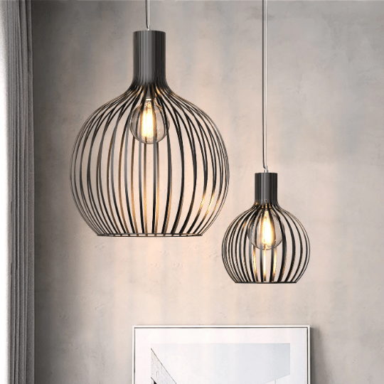 Two modern black wire pendant lights with exposed bulbs hang against a neutral wall, adding a stylish and contemporary touch to the entryway.
