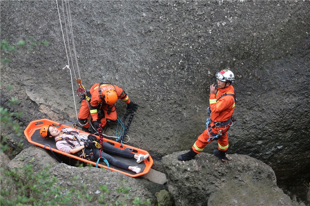 Rescue personnel using a basket stretcher in an emergency situation.