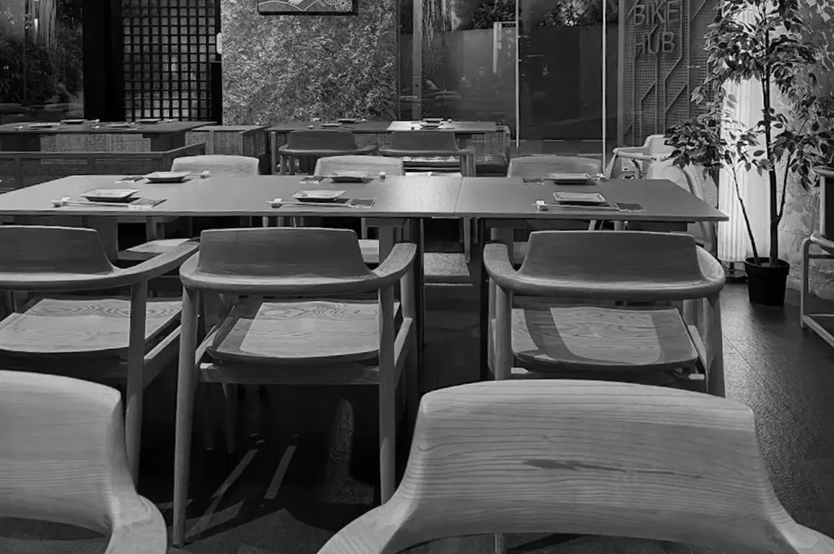 Ganko Sushi restaurant dining area with wooden tables, chairs, and neatly arranged place settings.