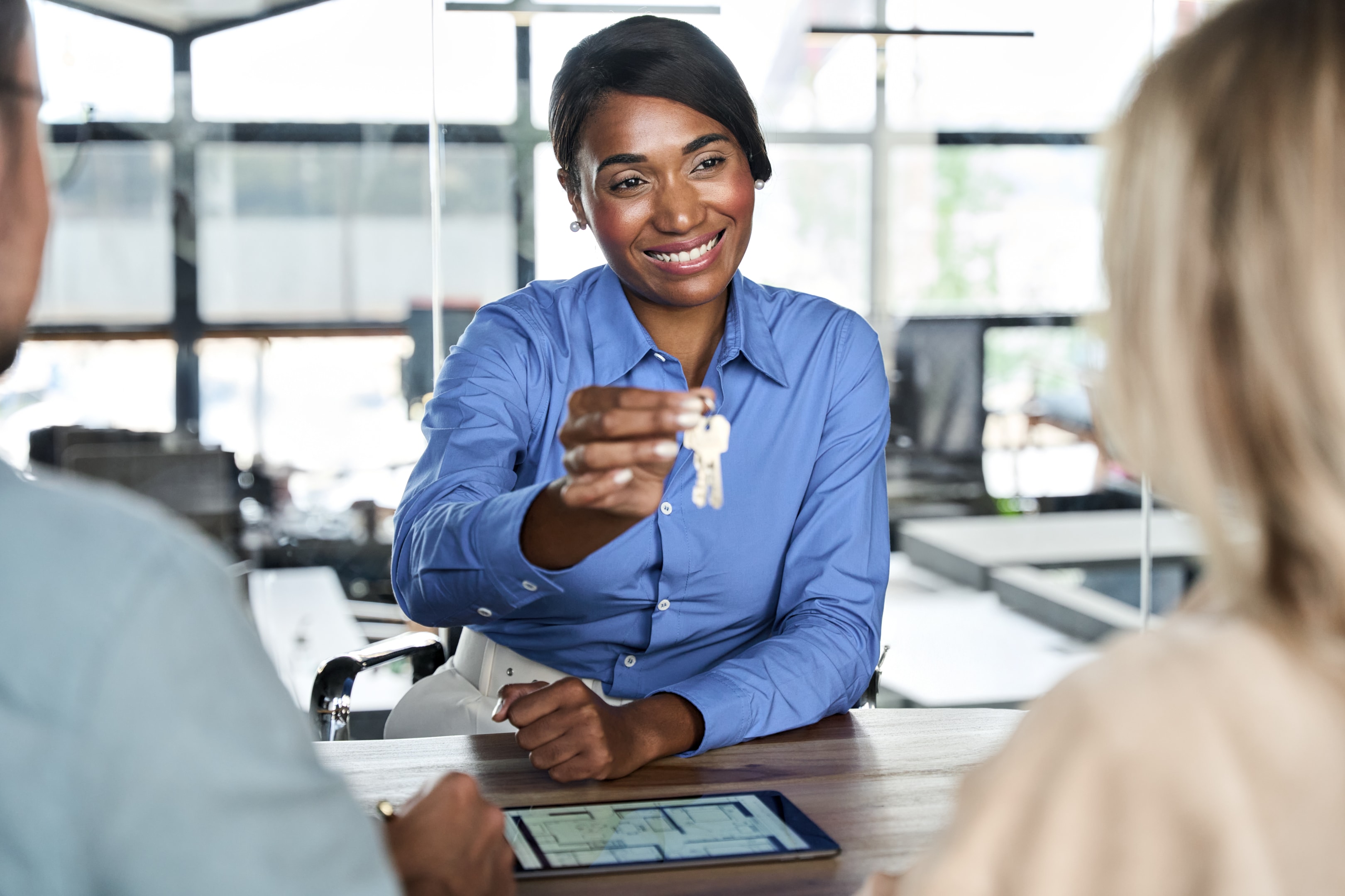 Property management team member handing rental keys during meeting