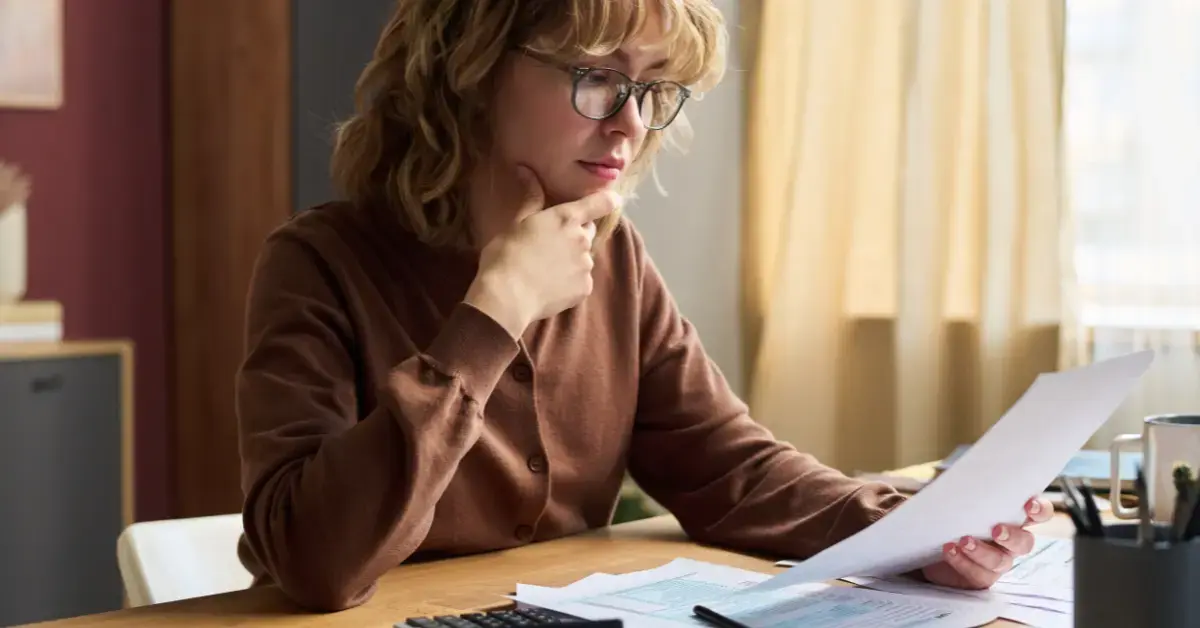 Confused woman comparing tax forms and asking is Schedule C the same as 1040?