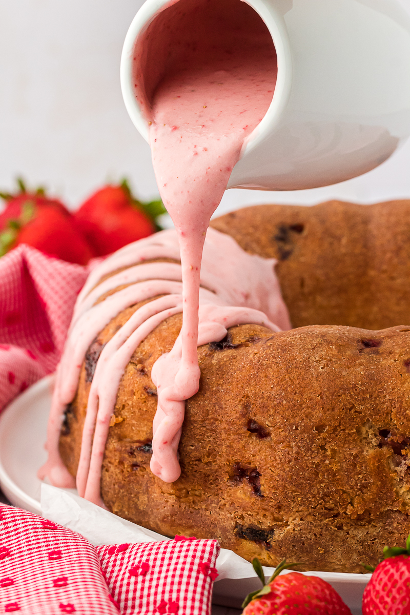 strawberry sweet glaze being poured on top of a strawberry pound cake