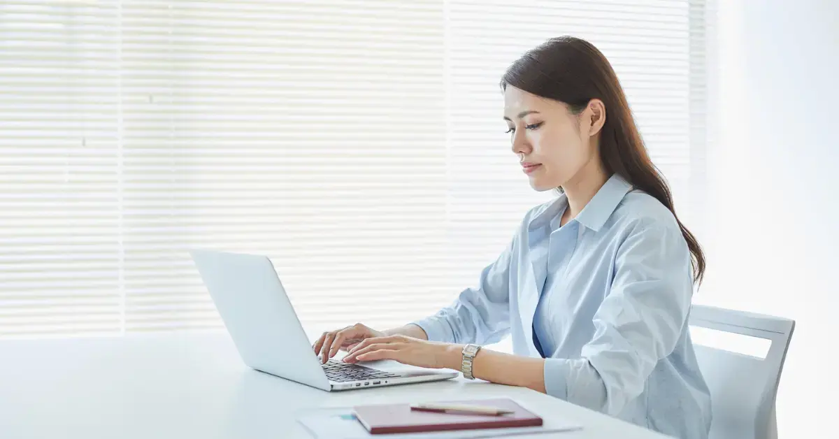 Woman managing her OnlyFans EIN number and tax documents in her home office.