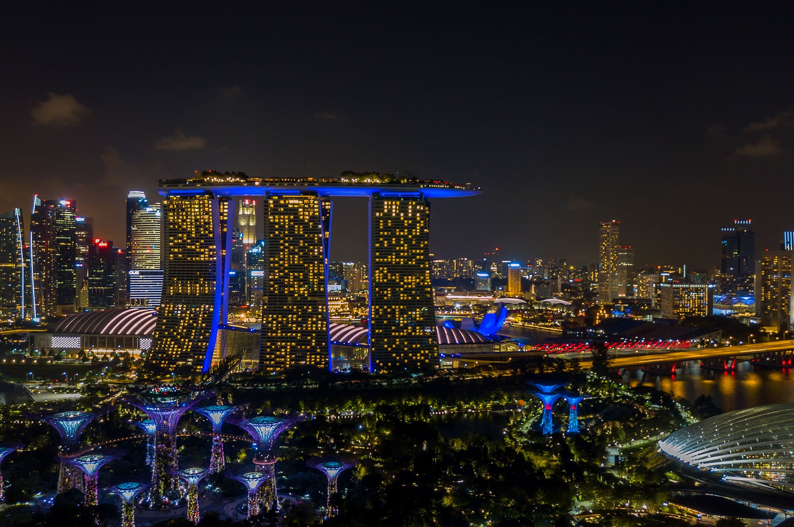 Singapore skyline at night with Marina Bay Sands and city lights.