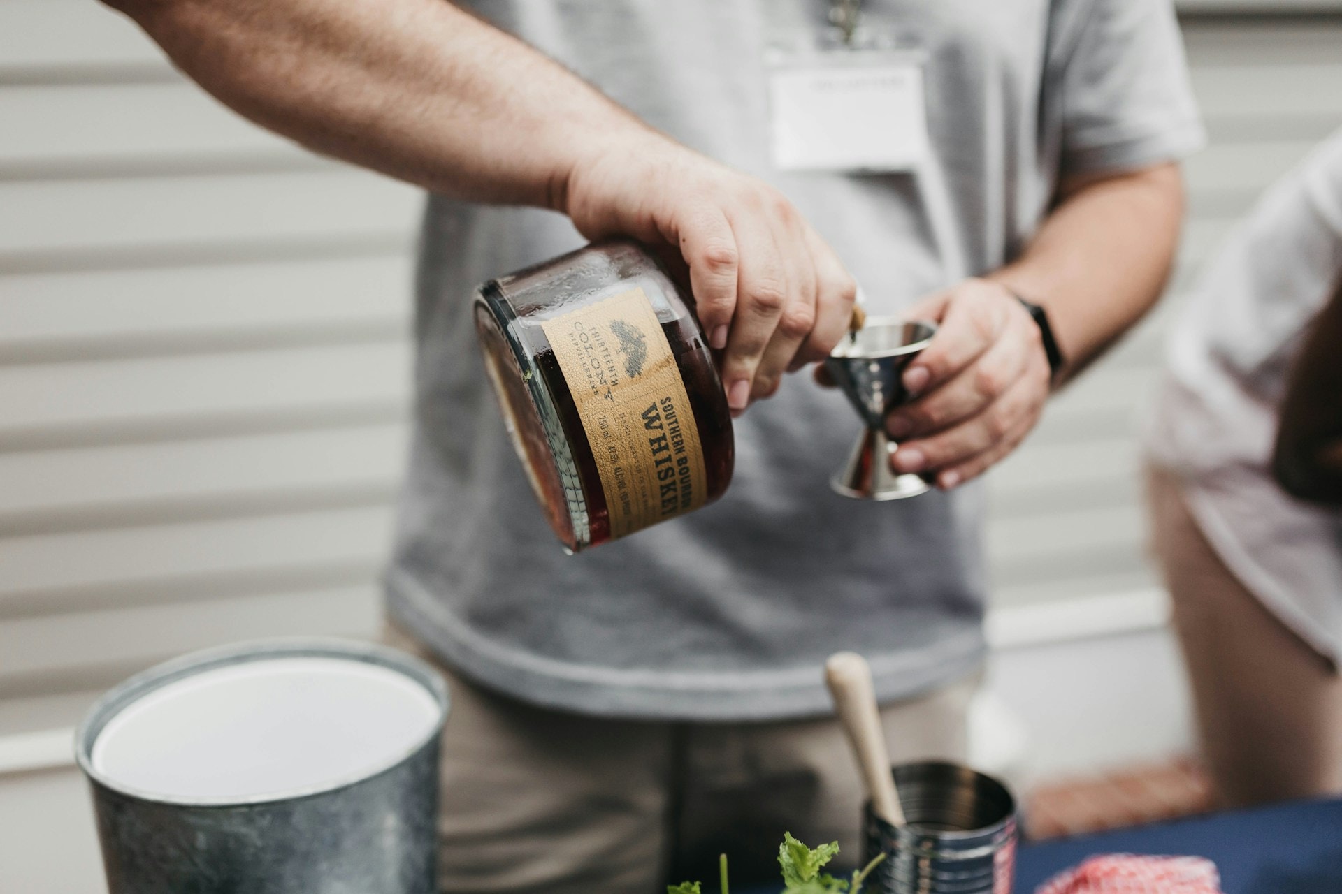 A close up of a man pouring a shot of Whiskey - https://unsplash.com/photos/person-pouring-whiskey-on-goblet-7WaKibxir18