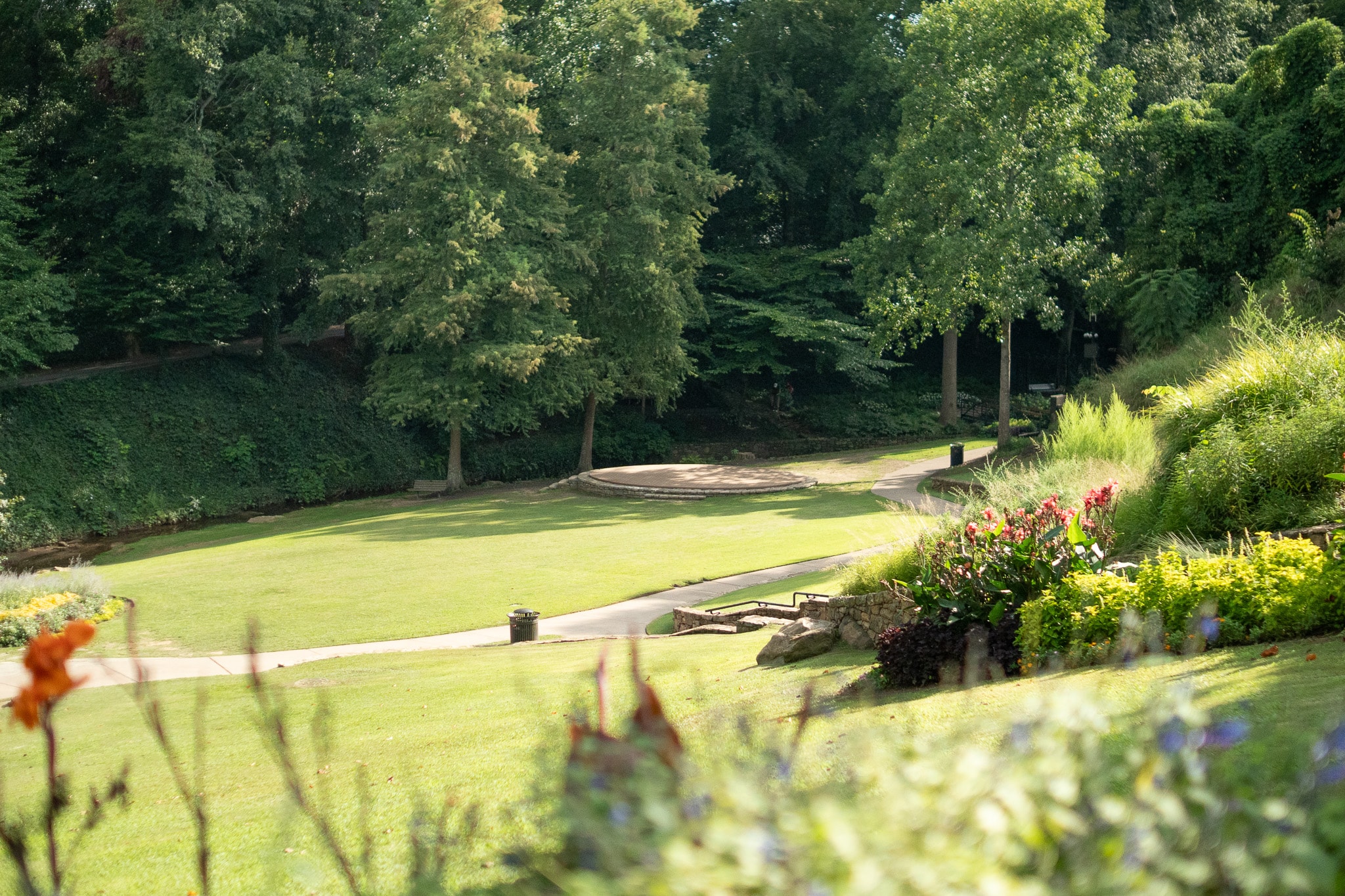 A family strolls along a tree-lined sidewalk in a suburban neighborhood, surrounded by charming homes and a community atmosphere typical of Greenville, SC. This family-friendly area offers a vibrant environment, ideal for enjoying outdoor activities and exploring nearby parks.