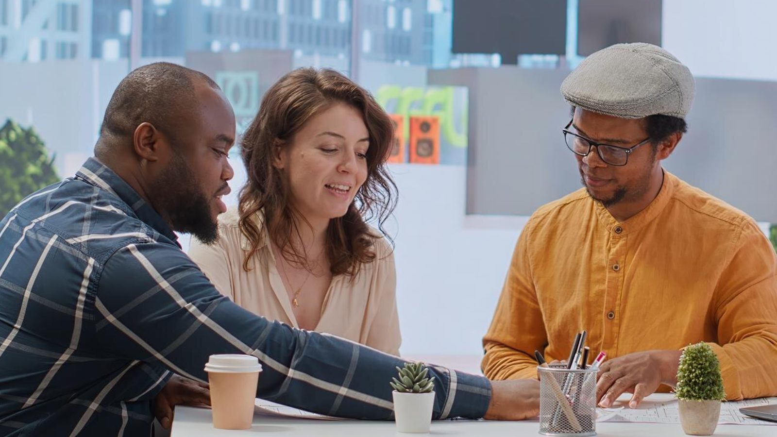 Team of coworkers smiling around a table, benefiting from an easy-to-manage calling plan with TeamMate.