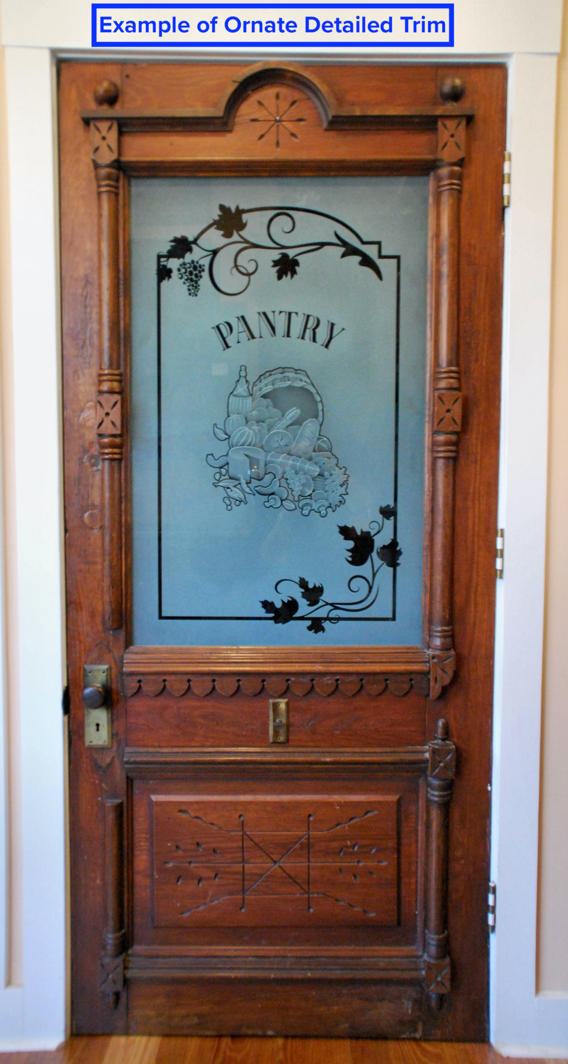 A pantry door with unique, ornate trim details