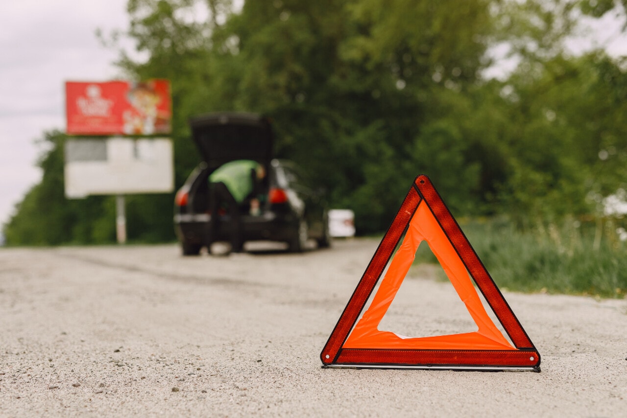 Uszkodzone auto należy ustawić tak, by nie przeszkadzało w ruchu drogowym. Źródło: https://www.freepik.com/free-photo/car-with-problems-red-triangle-warn-other-road-users_8897457.htm#fromView=search&page=1&position=8&uuid=ff089b5d-4a42-44bf-b3de-9272bbd5e915&query=kontrola+drogowa