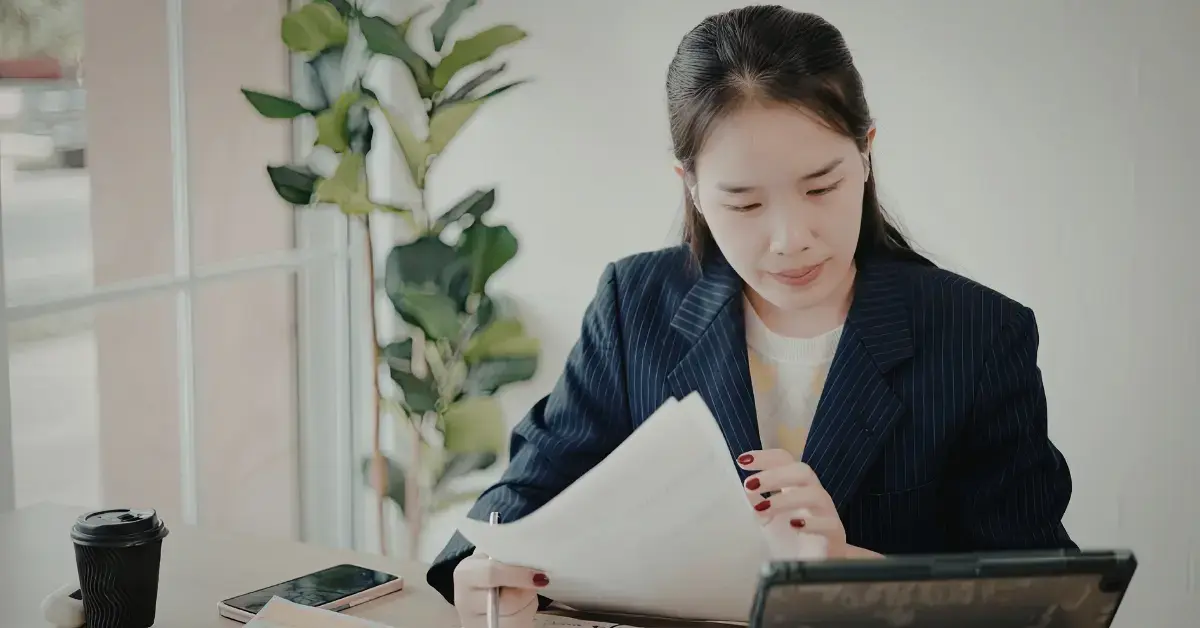 Woman reviewing tax documents and learning Form 8889 instructions for HSA reporting.