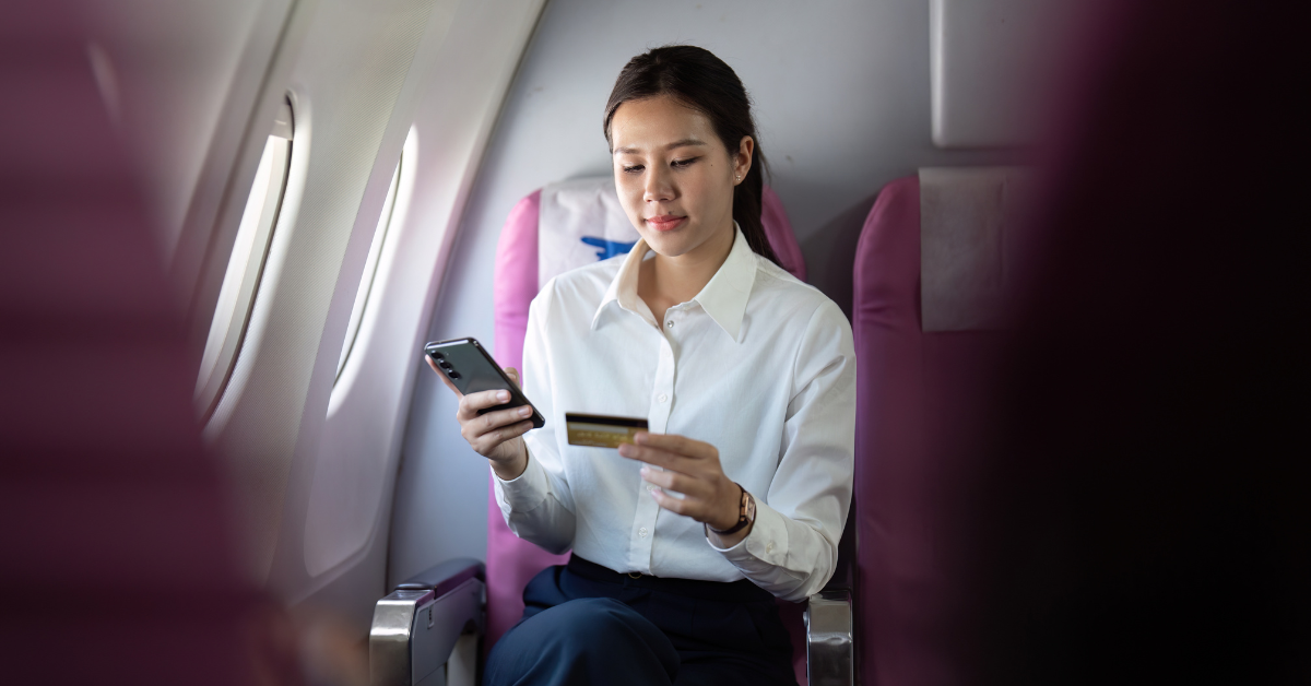 A woman holding a phone in one hand and a card in the other, illustrating OnlyFans payment methods, managing income, and tracking creator finances.