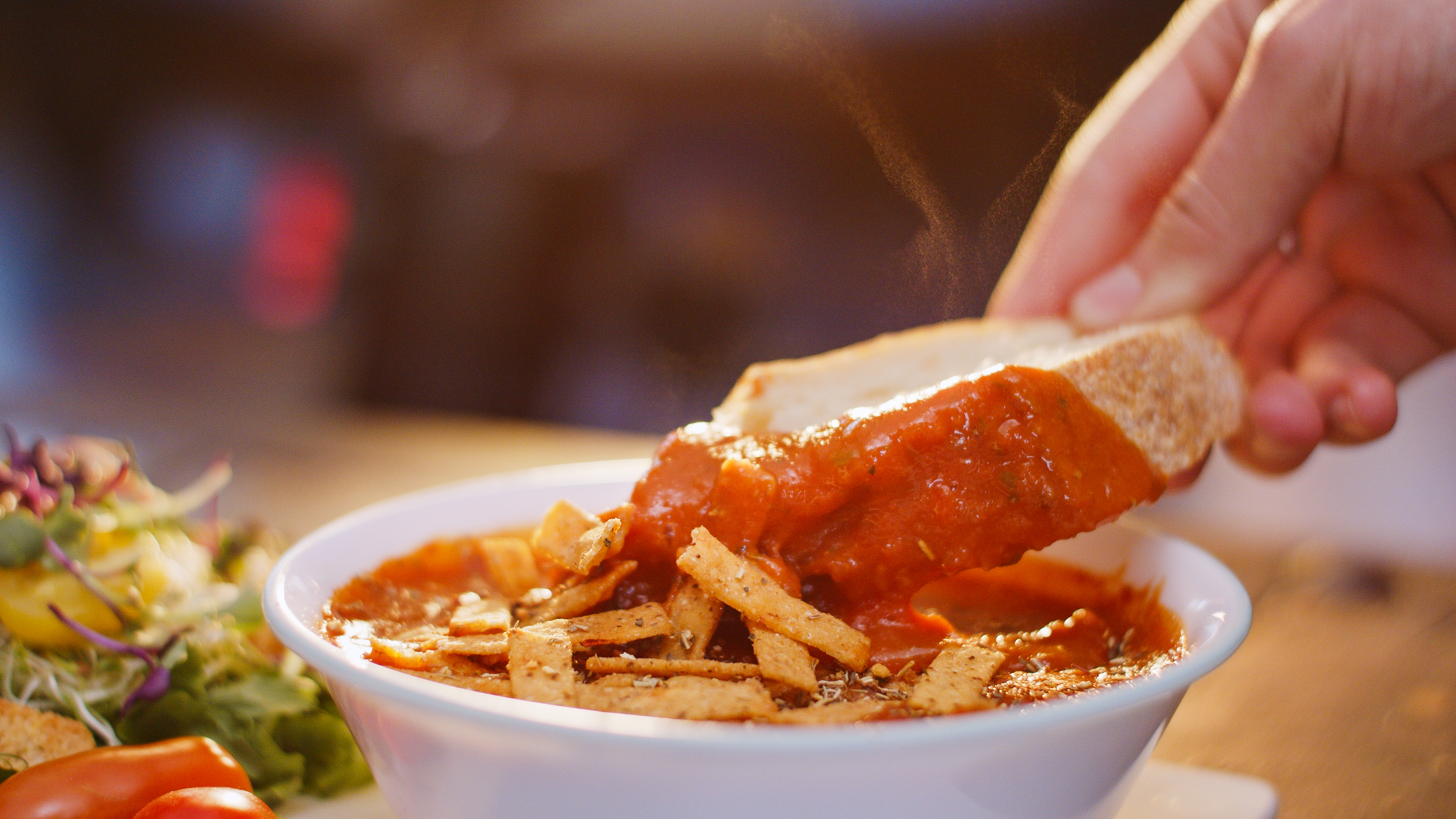 Fresh bread dipped into Proper Good's Tomato Basil Soup