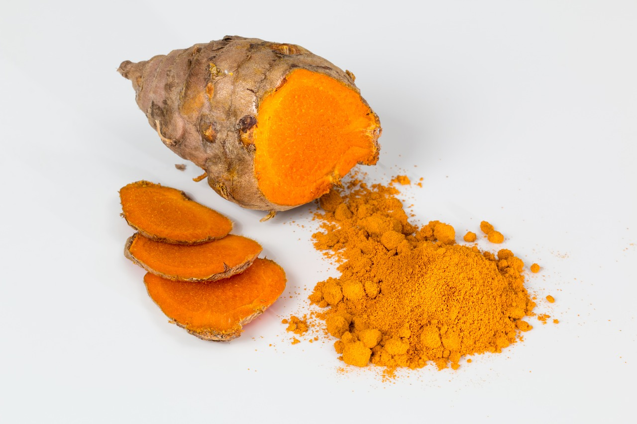 An image of turmeric root and powder on a light background.