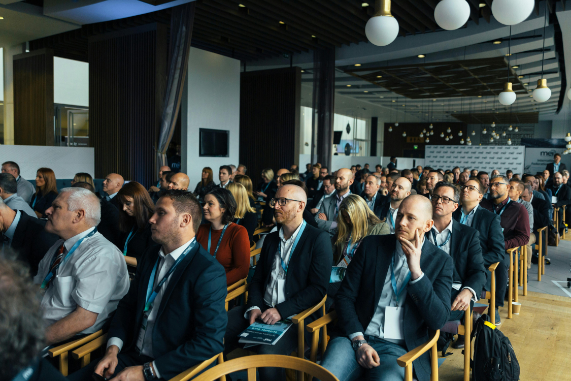 Audience of professionals attending a broker networking event and panel discussion