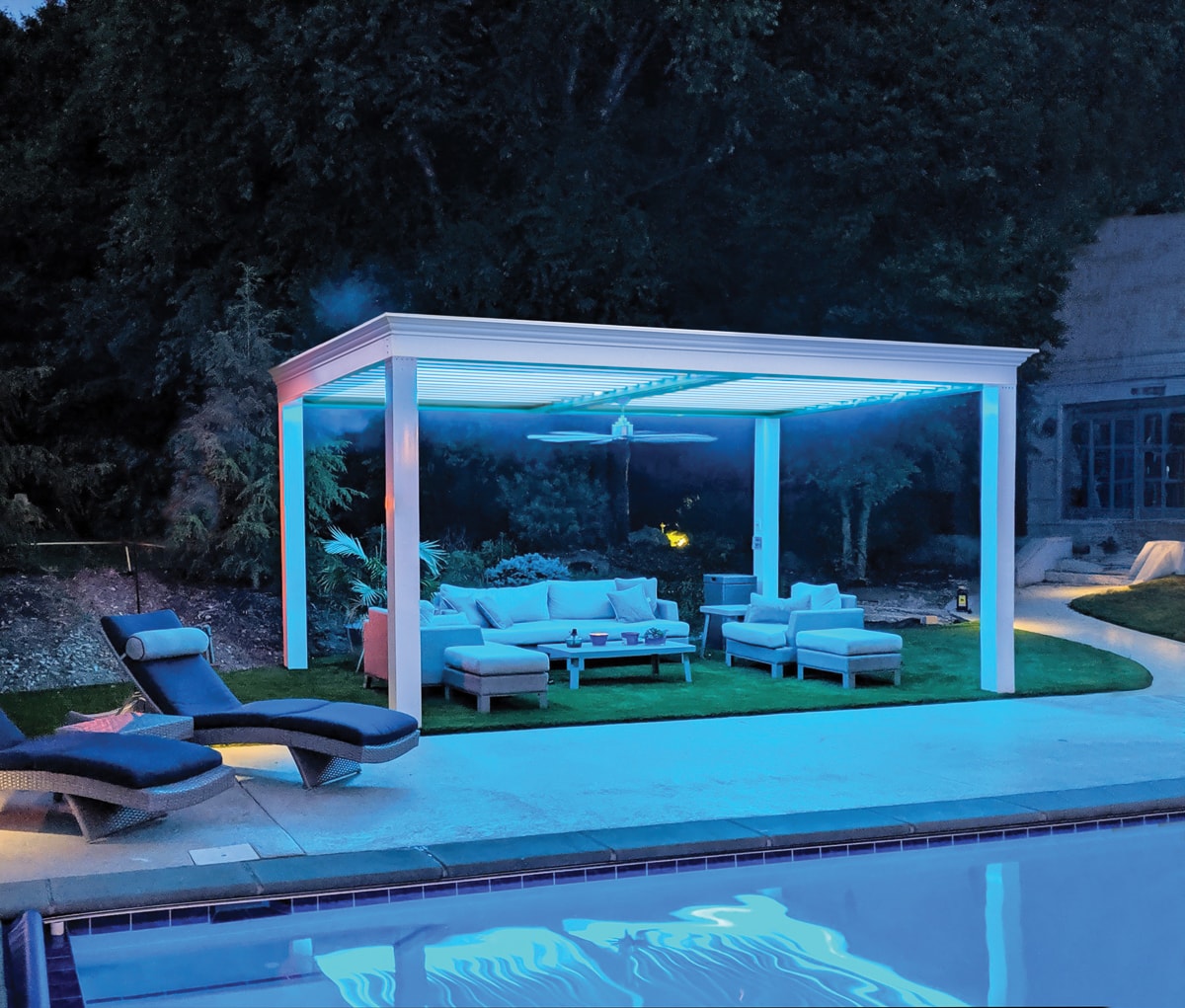Poolside pergola with outdoor seating, outdoor lighting and dedicsted greenspace.