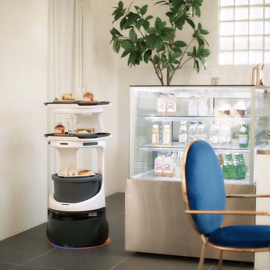 A Servi robot holding multiple different food and drink items preparing for delivery.