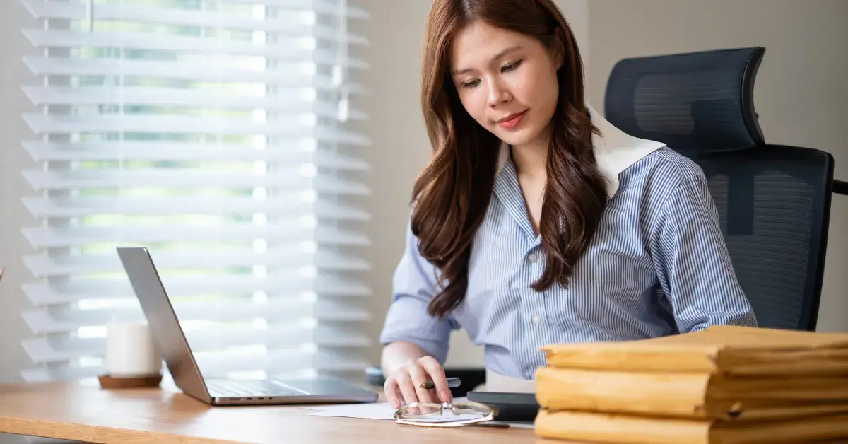 Woman reviewing financial records and Form 433-A documents for OnlyFans tax compliance.