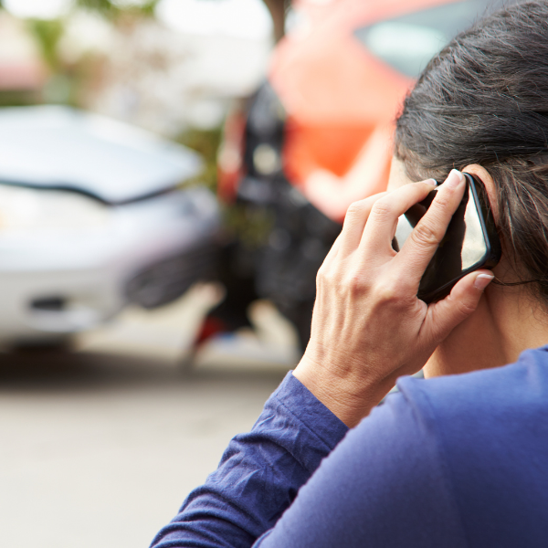 An image of a person making a phone call to report an 18 wheeler accident to their insurance company.