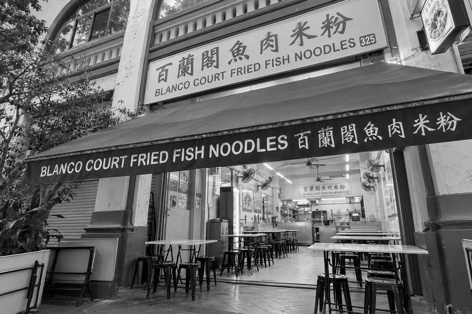 The entrance of a fish soup restaurant with a bright illuminated sign, promotional poster, and clean modern storefront.