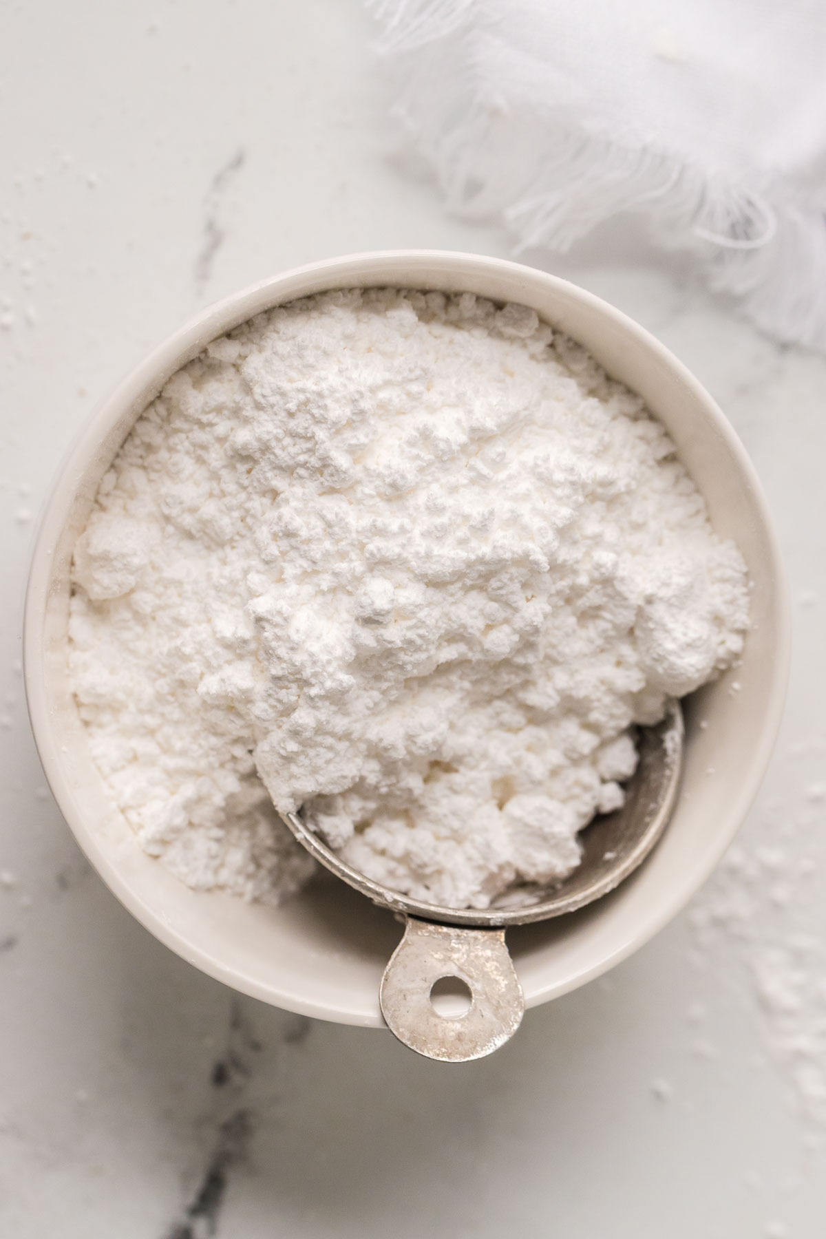 powdered sugar in a bowl with a measuring cup