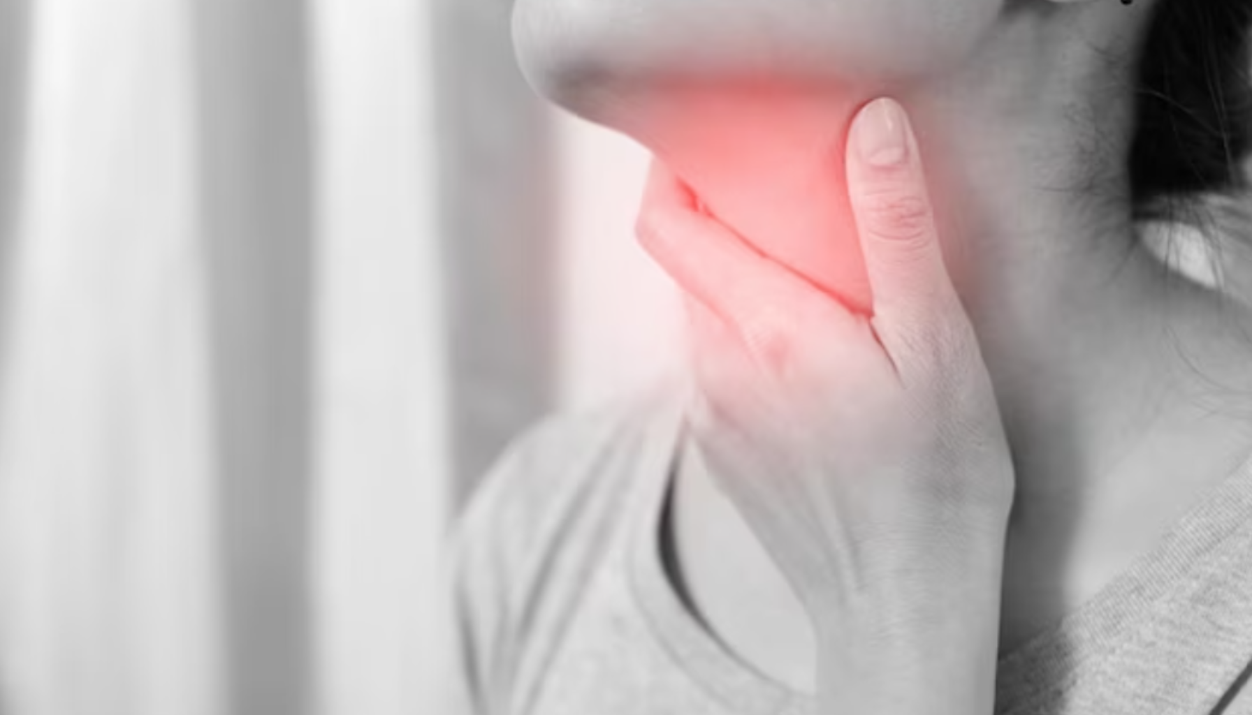 Mandler i Halsen: Når Hevelse Påvirker Munnen og Pusten 12 Nærbilde av person som holder under kjeven, rødt markert område indikerer smerte eller betennelse.