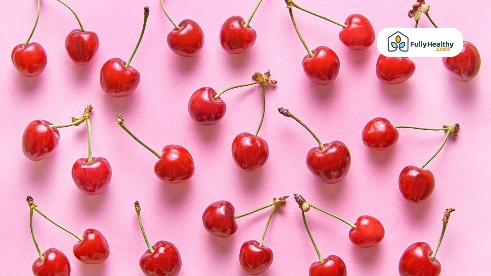 Red cherries evenly spaced on pastel pink background, flat lay style.