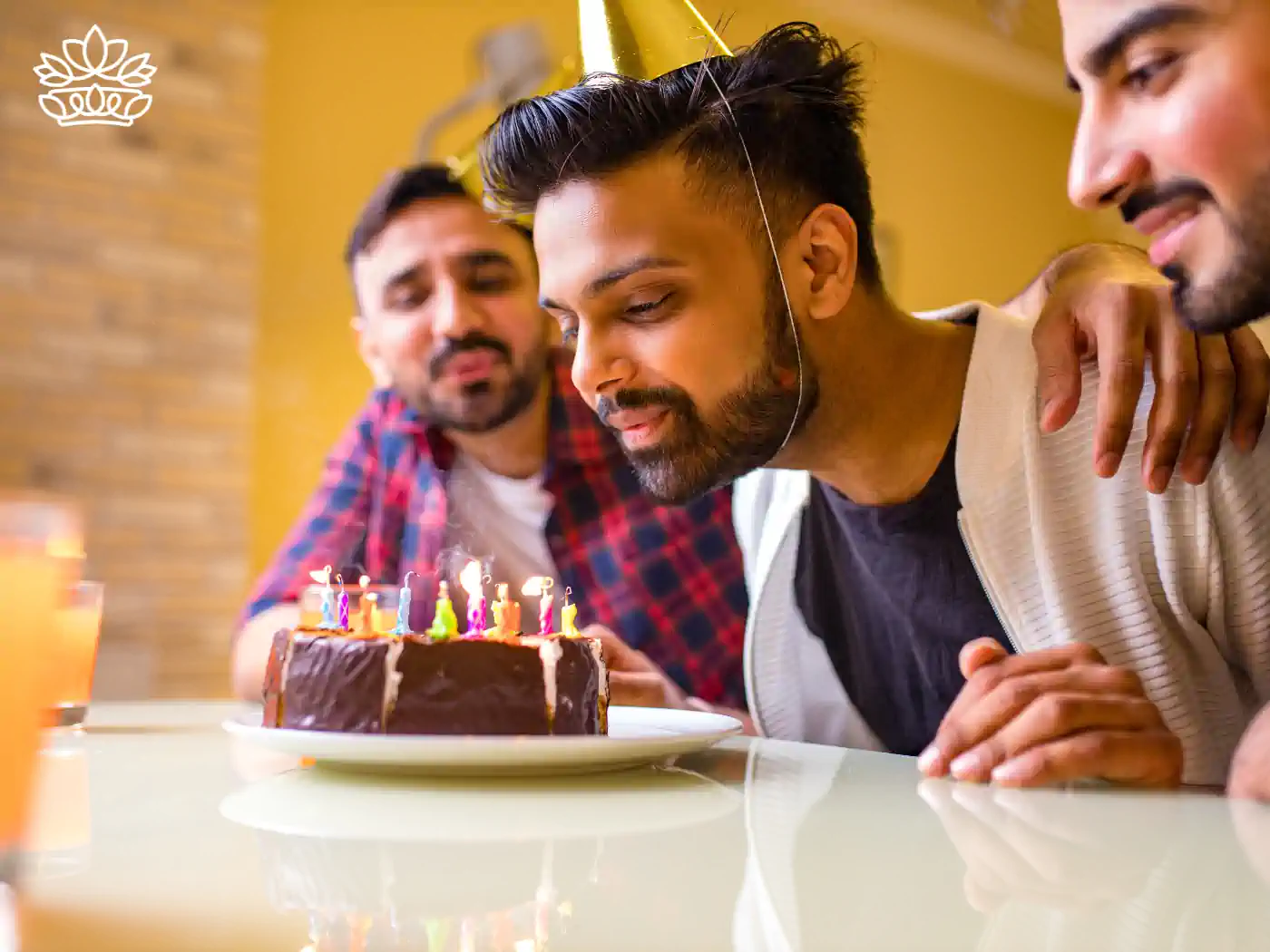 Three men gathered around a birthday cake with lit candles, making a wish - Fabulous Flowers and Gifts, Sagittarius Flowers and Gifts