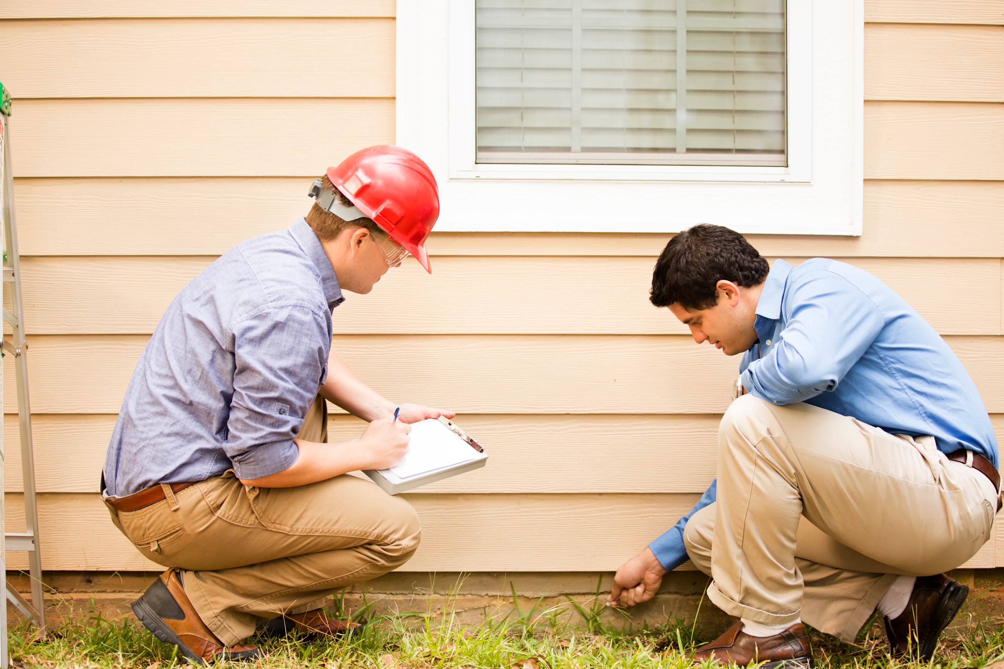 Certified home inspector looking for signs of cracks, breaks, and mold in the house exterior 