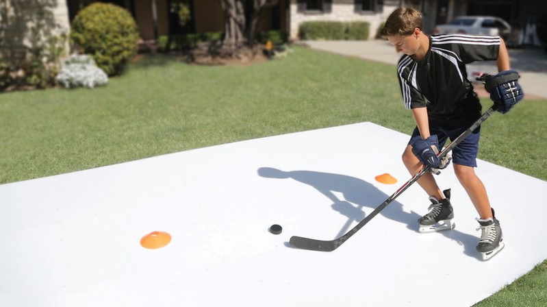 Boy playing ice hockey in backyard