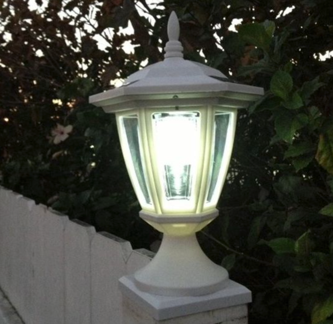 White fence with lamp light on fence post