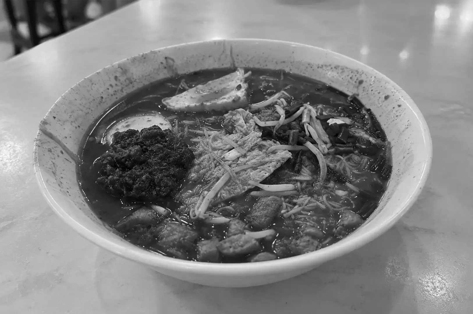A serving of mee siam with fine rice vermicelli, shredded toppings, and a tangy sauce popular at local hawker stalls.