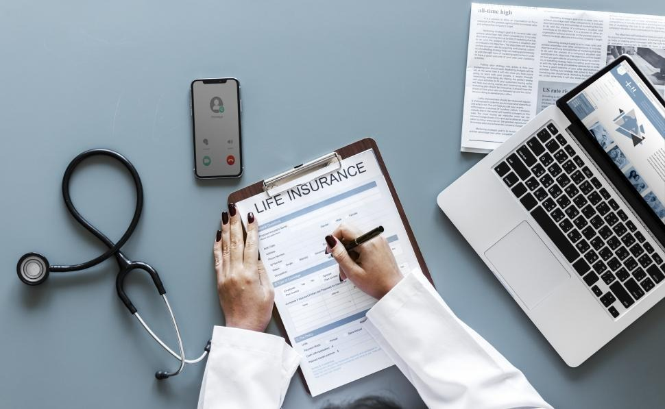 Doctor checking life insurance form