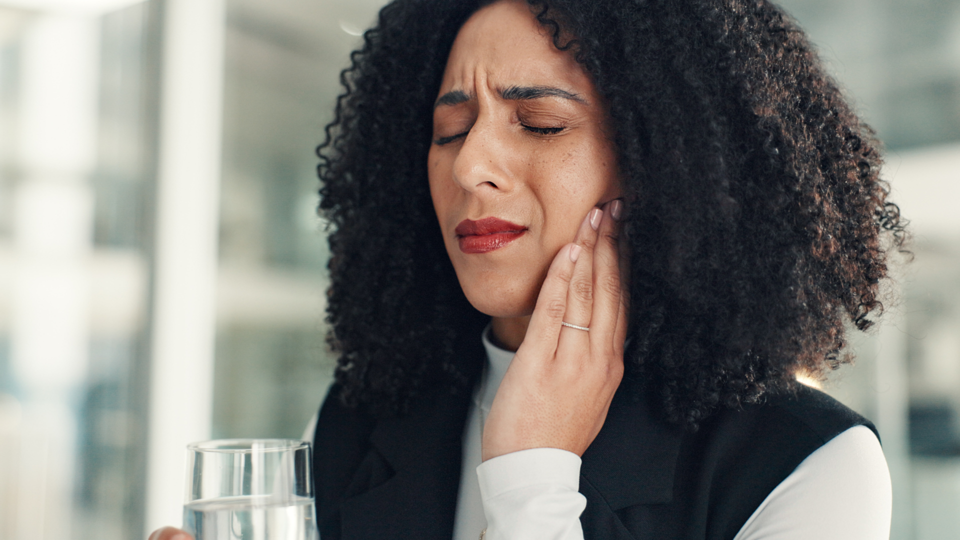 Person holding hand to their jaw showing tooth pain.