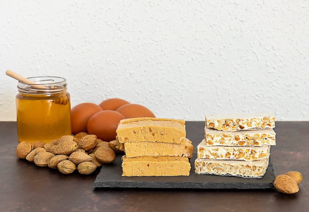 Ingredienti tradizionali per il torrone, come mandorle e miele.
