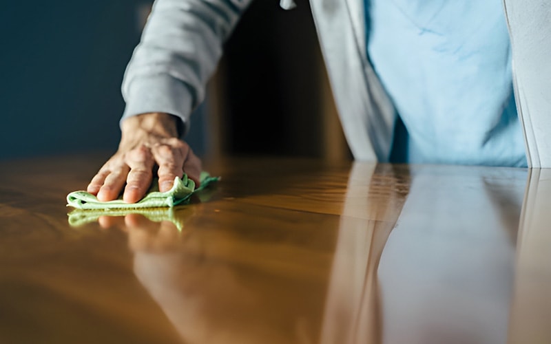 A man polishing his old wooden dinner table
