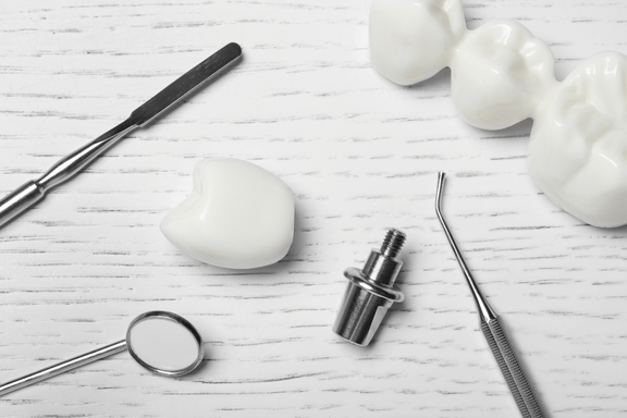 dental implant pieces beside a dental bridge