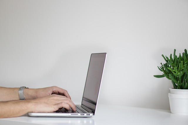 Hands typing on a laptop