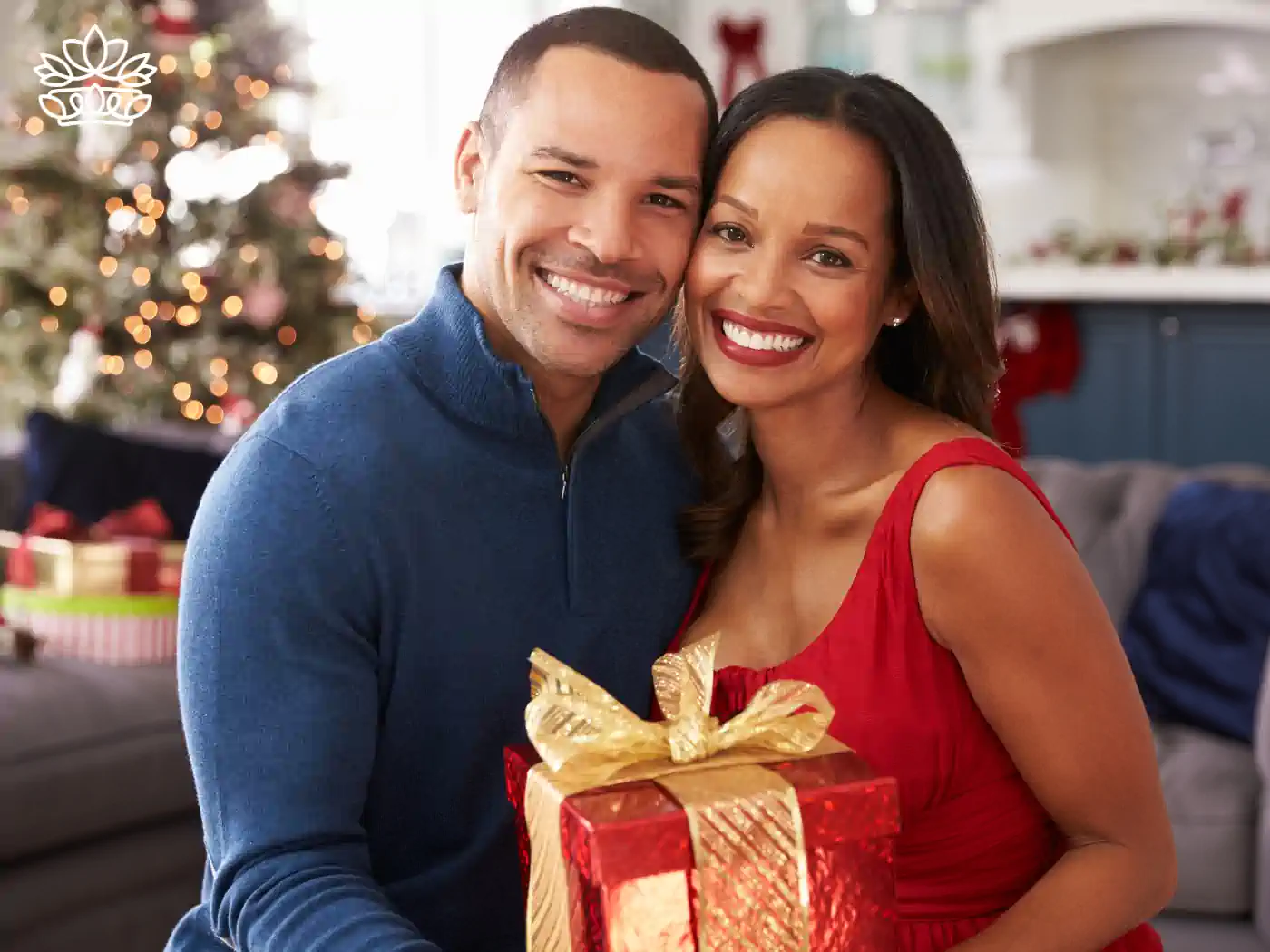 A happy couple exchanging a gift box in a festive setting - Fabulous Flowers and Gifts - Nationwide Gift Box Delivery