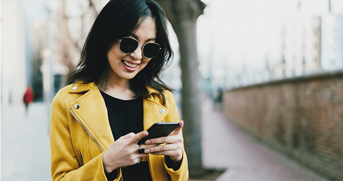 Dark haired woman sending a text.