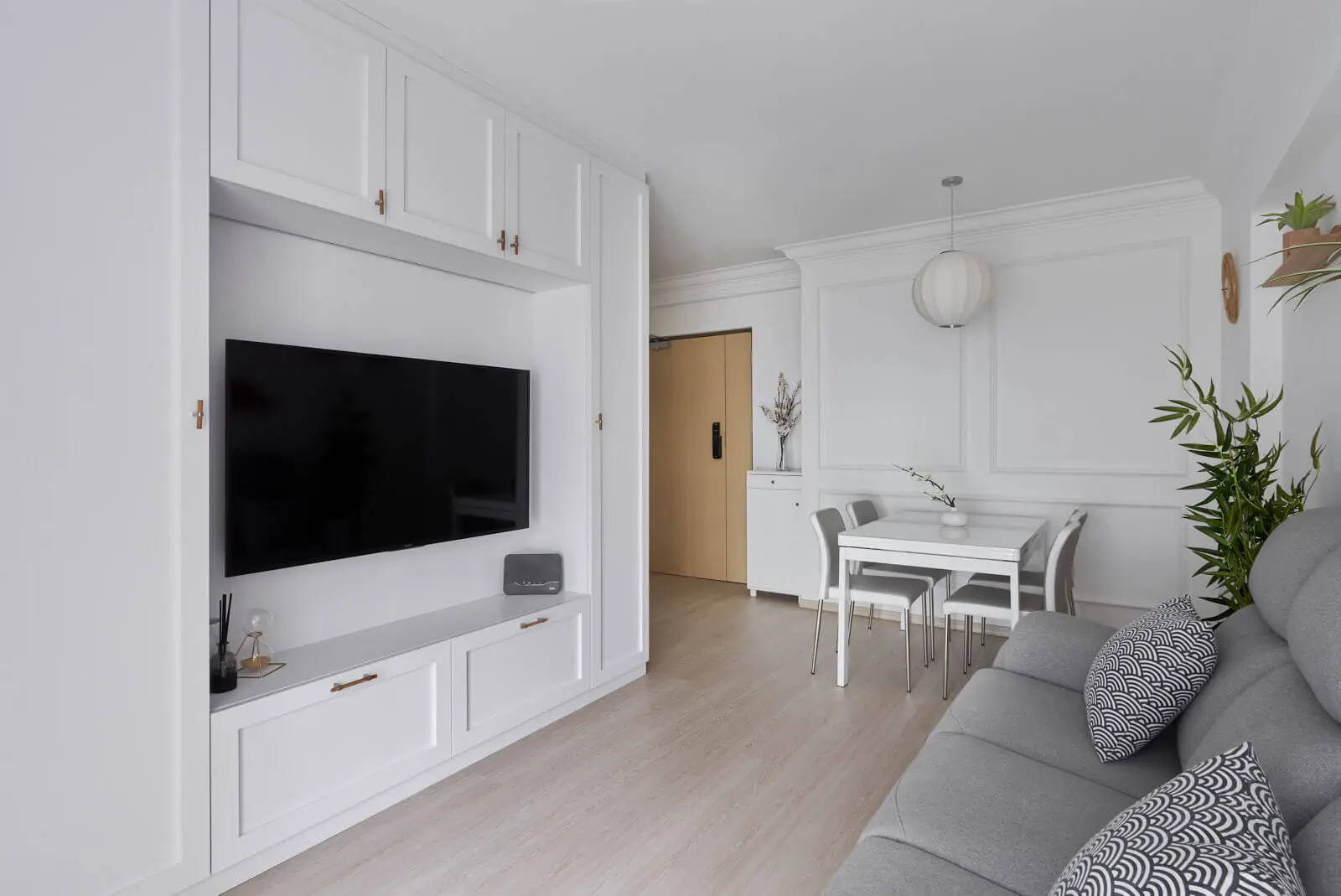 Sleek white built-in cabinetry and dining area showing space-saving condo interior design for compact units.