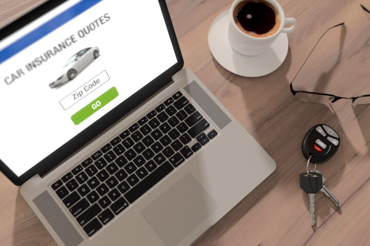 A laptop, a cup of coffee, car keys, and eye glasses on the table